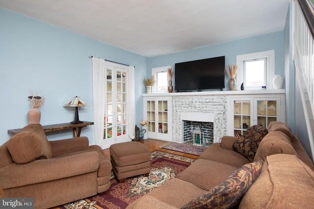 living room with a fireplace, a wealth of natural light, and wood-type flooring