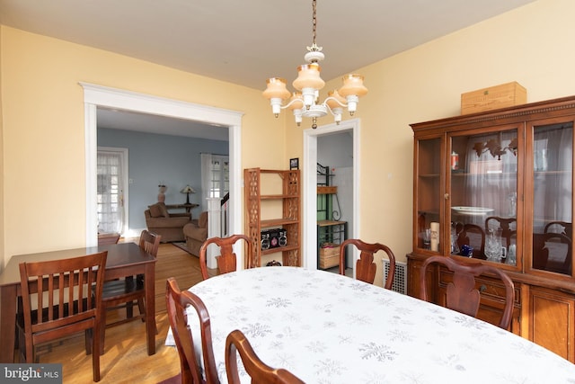 dining room featuring an inviting chandelier and light hardwood / wood-style flooring