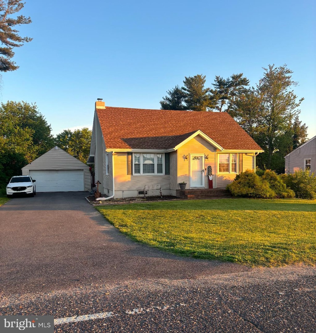 view of front facade with a garage, an outdoor structure, and a front yard