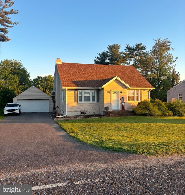 view of front facade with a garage, an outdoor structure, and a front yard