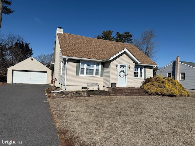 view of front of home featuring a garage, a shingled roof, a chimney, an outbuilding, and a front yard