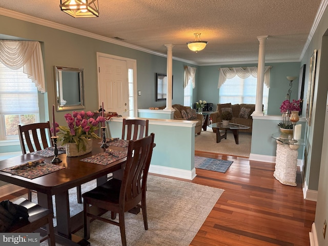 dining space featuring decorative columns, crown molding, hardwood / wood-style floors, and a textured ceiling