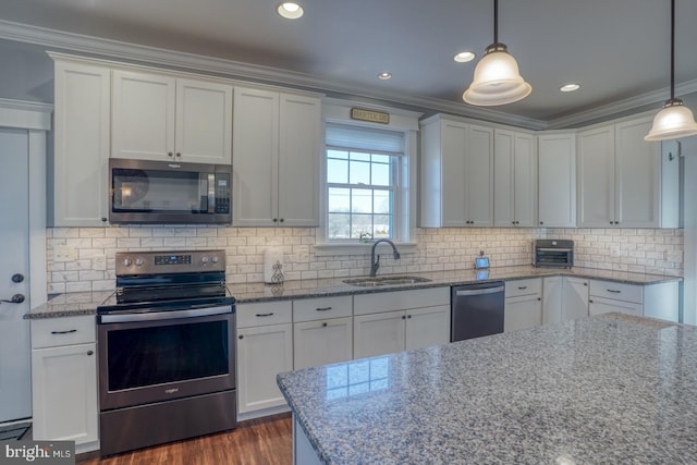 kitchen with pendant lighting, white cabinetry, sink, ornamental molding, and stainless steel appliances