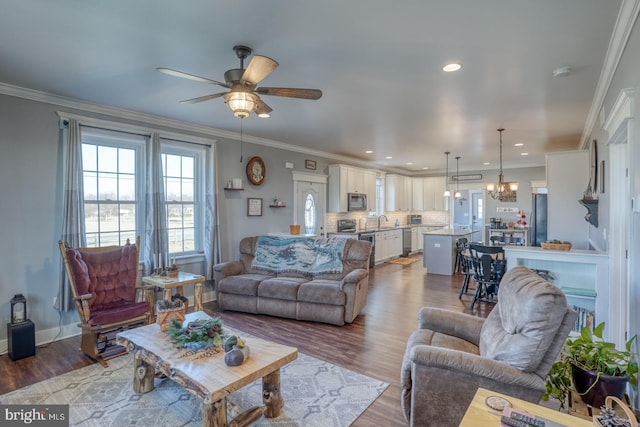 living room with sink, wood-type flooring, and ornamental molding