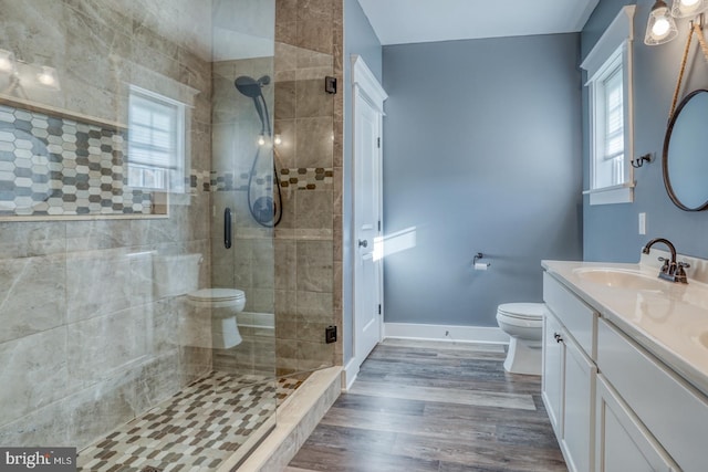 bathroom with a healthy amount of sunlight, vanity, toilet, and walk in shower