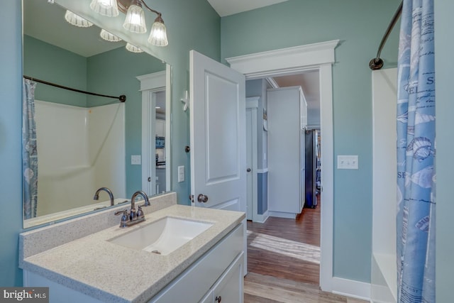 bathroom featuring hardwood / wood-style flooring, vanity, and shower / bath combination with curtain