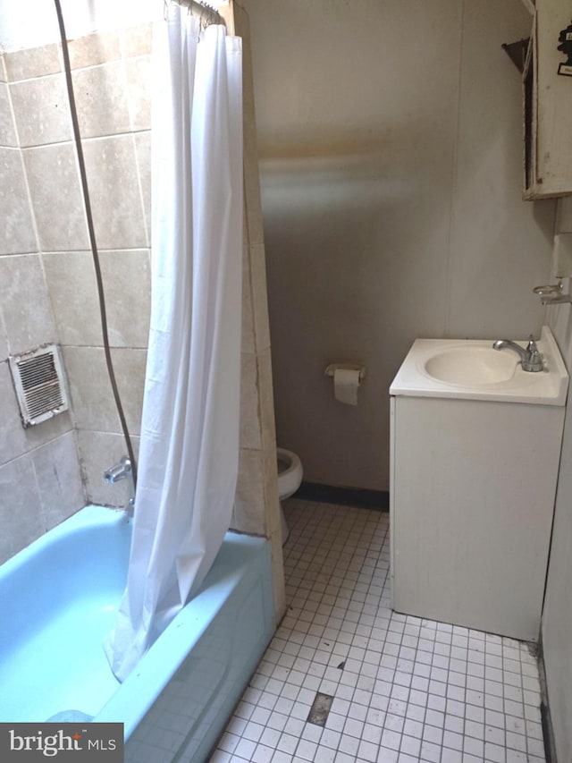 full bathroom with vanity, shower / tub combo with curtain, tile patterned floors, and toilet