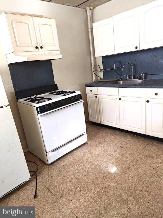 kitchen featuring white range with gas cooktop, sink, and white cabinetry