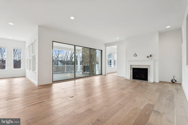 unfurnished living room featuring a wealth of natural light and light hardwood / wood-style flooring