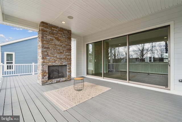 deck with an outdoor stone fireplace