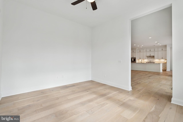 spare room featuring ceiling fan and light hardwood / wood-style floors