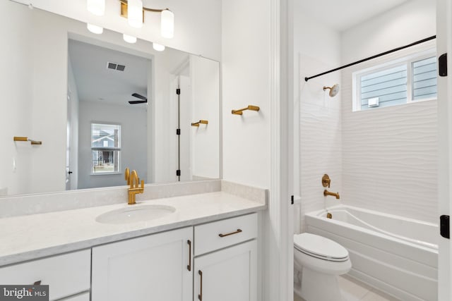 full bathroom with vanity, tiled shower / bath, toilet, and a healthy amount of sunlight