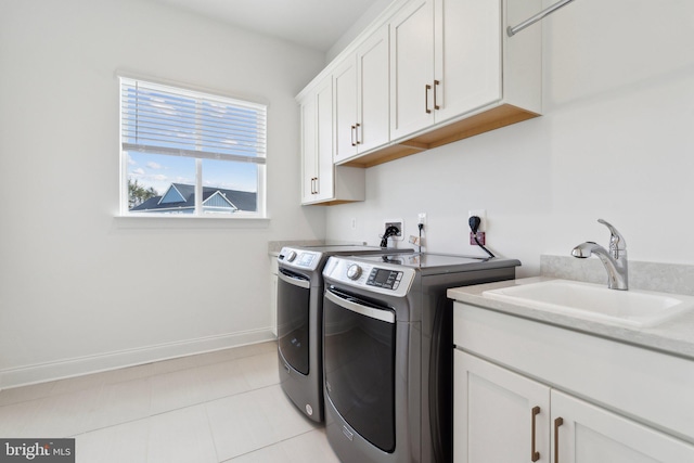 laundry area featuring cabinets, separate washer and dryer, sink, and light tile patterned floors