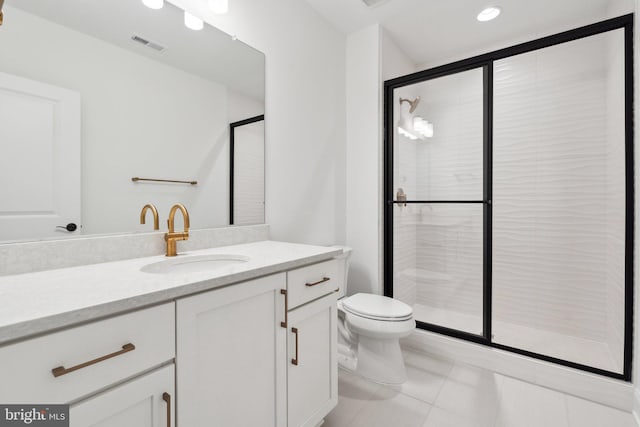 bathroom with tile patterned flooring, vanity, a shower with shower door, and toilet