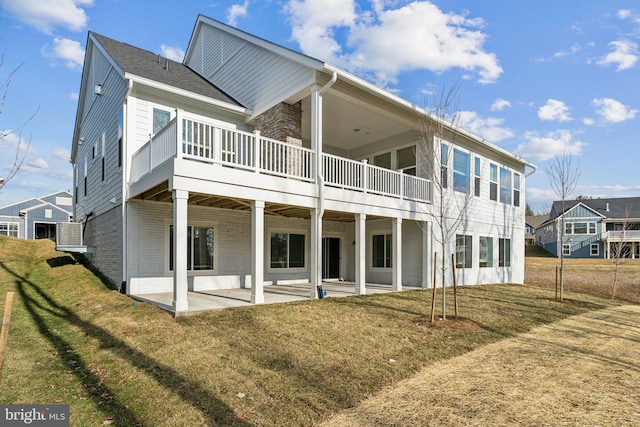 rear view of property with a yard and a patio area