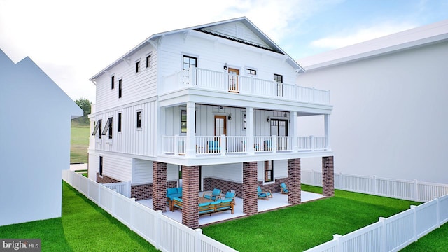 view of front facade with a balcony, a patio area, and a front lawn