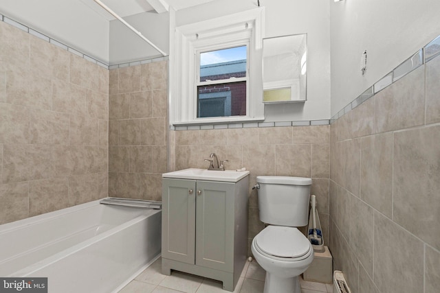 full bathroom with washtub / shower combination, toilet, tile walls, vanity, and tile patterned flooring