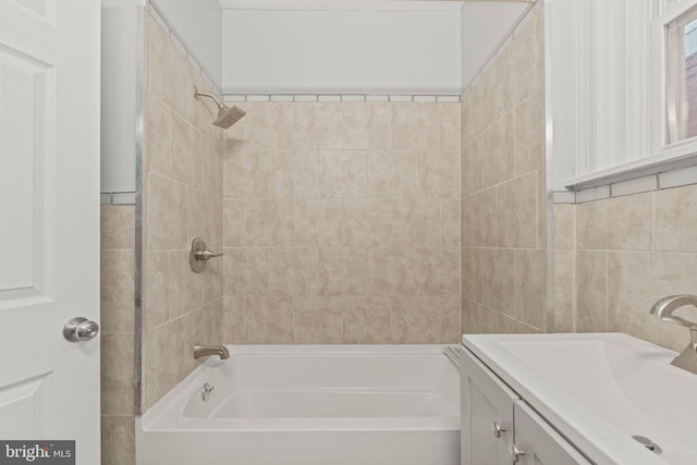 bathroom with tiled shower / bath, vanity, and tile walls