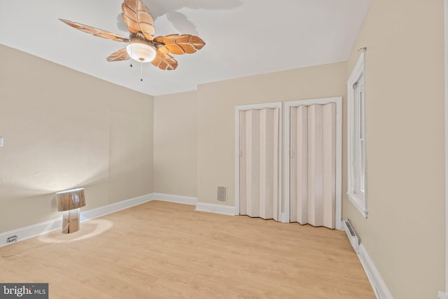 unfurnished room featuring ceiling fan, a baseboard radiator, and light hardwood / wood-style flooring