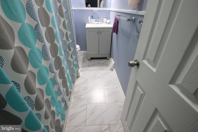 bathroom featuring vanity, curtained shower, and toilet