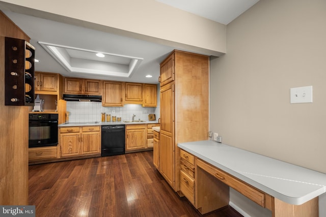 kitchen with tasteful backsplash, dark hardwood / wood-style flooring, black appliances, a tray ceiling, and sink