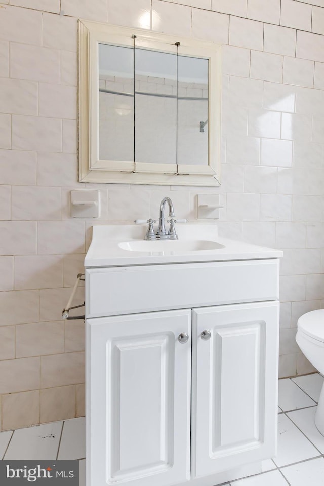 443 Manor St, Lancaster, PA 17603 - half bath featuring tile patterned flooring, toilet, vanity, and tile walls