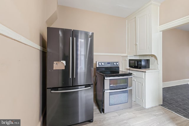 443 Manor St, Lancaster, PA 17603 - kitchen with white cabinets, light countertops, light wood-type flooring, and appliances with stainless steel finishes
