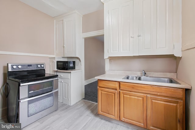 443 Manor St, Lancaster, PA 17603 - kitchen with a sink, black microwave, light wood-style floors, double oven range, and light countertops