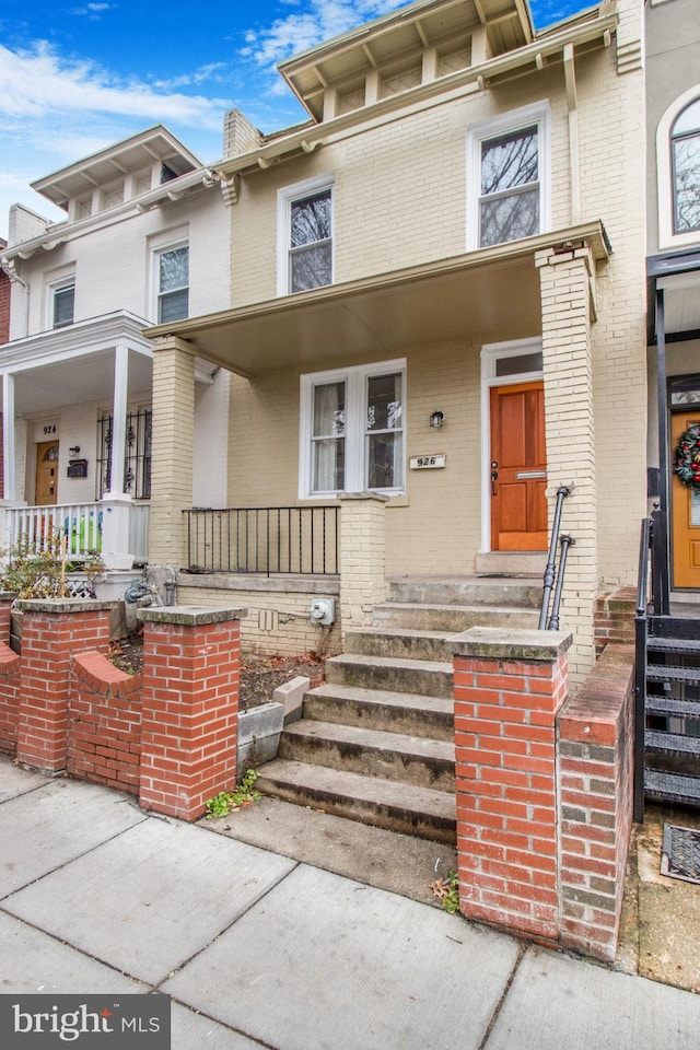 townhome / multi-family property featuring covered porch