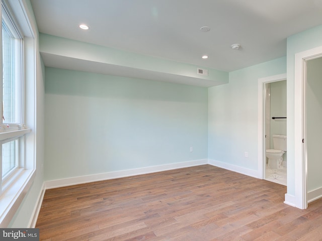 spare room featuring light hardwood / wood-style floors and a wealth of natural light