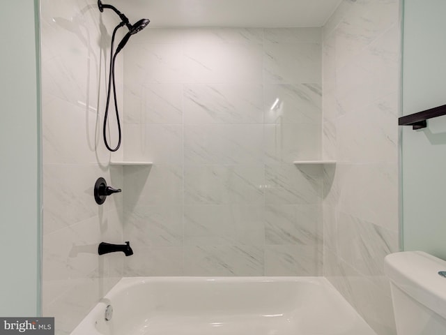 bathroom featuring tiled shower / bath combo and toilet