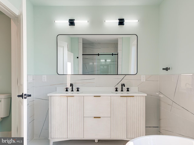 bathroom featuring tile walls, vanity, toilet, and a tile shower