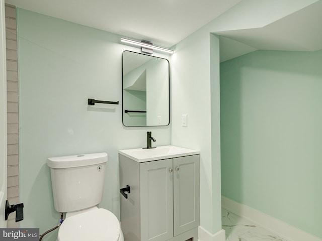 bathroom featuring vanity, vaulted ceiling, and toilet