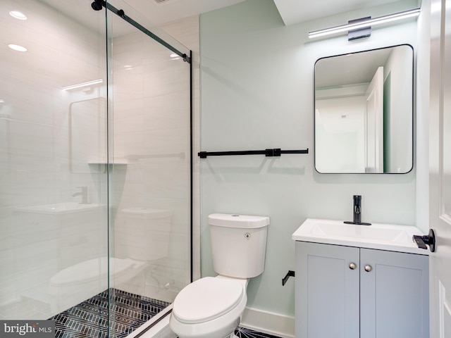 bathroom featuring vanity, a shower with shower door, and toilet