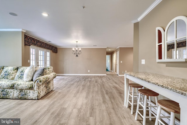 living room with crown molding, a chandelier, and light hardwood / wood-style flooring