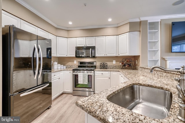 kitchen with white cabinetry, sink, light stone counters, and appliances with stainless steel finishes