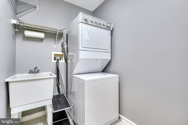 washroom featuring sink and stacked washing maching and dryer