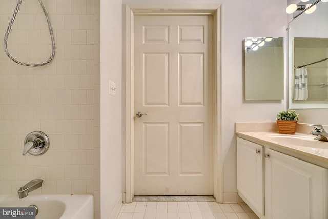 bathroom with tiled shower / bath combo, vanity, and tile patterned floors