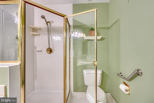 bathroom featuring a shower with door and toilet