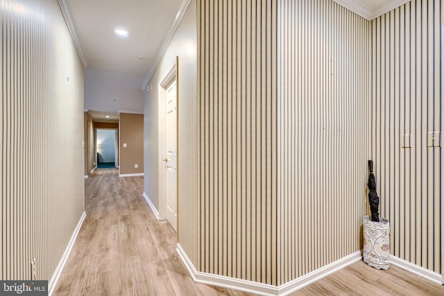 hallway with ornamental molding and light hardwood / wood-style floors