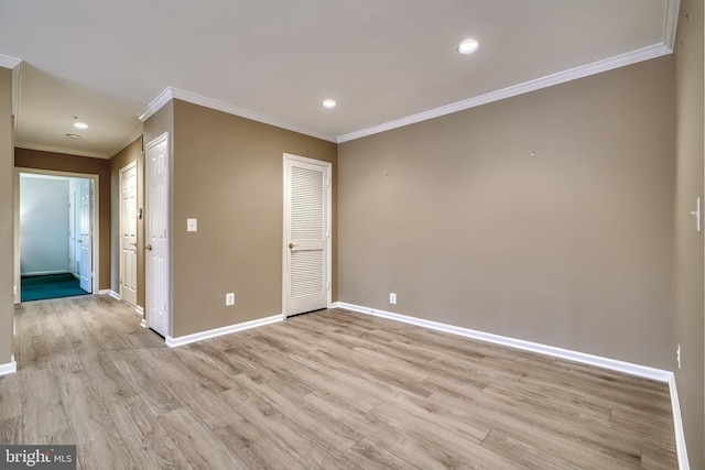 empty room featuring crown molding and light hardwood / wood-style floors