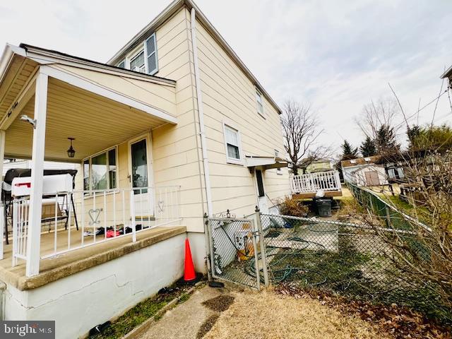 view of side of property featuring covered porch