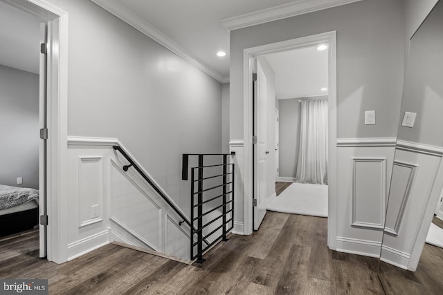 staircase featuring wood-type flooring and ornamental molding