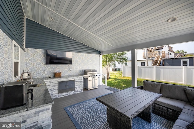 view of patio with a grill, an outdoor hangout area, exterior kitchen, and a deck