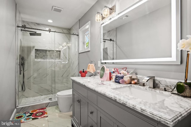 bathroom with vanity, toilet, and a shower with door