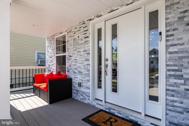 doorway to property with cooling unit and covered porch