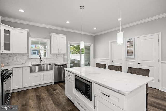 kitchen with pendant lighting, sink, white cabinetry, and stainless steel appliances