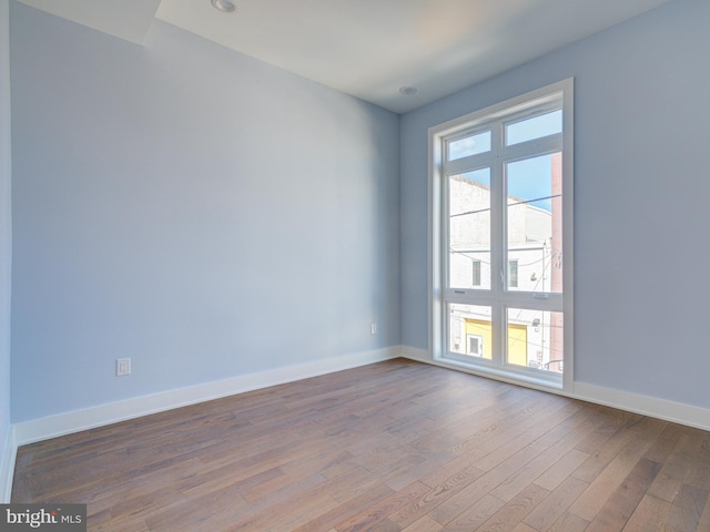 unfurnished room with hardwood / wood-style flooring