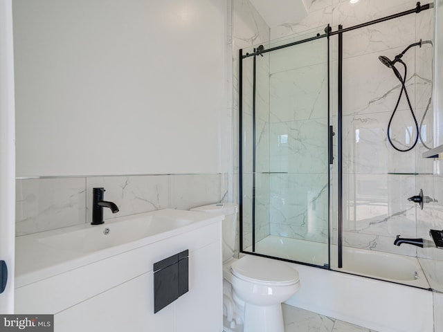 full bathroom featuring sink, shower / bath combination with glass door, and toilet