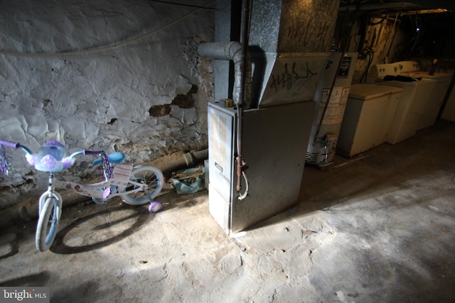 utility room featuring independent washer and dryer, heating unit, and gas water heater